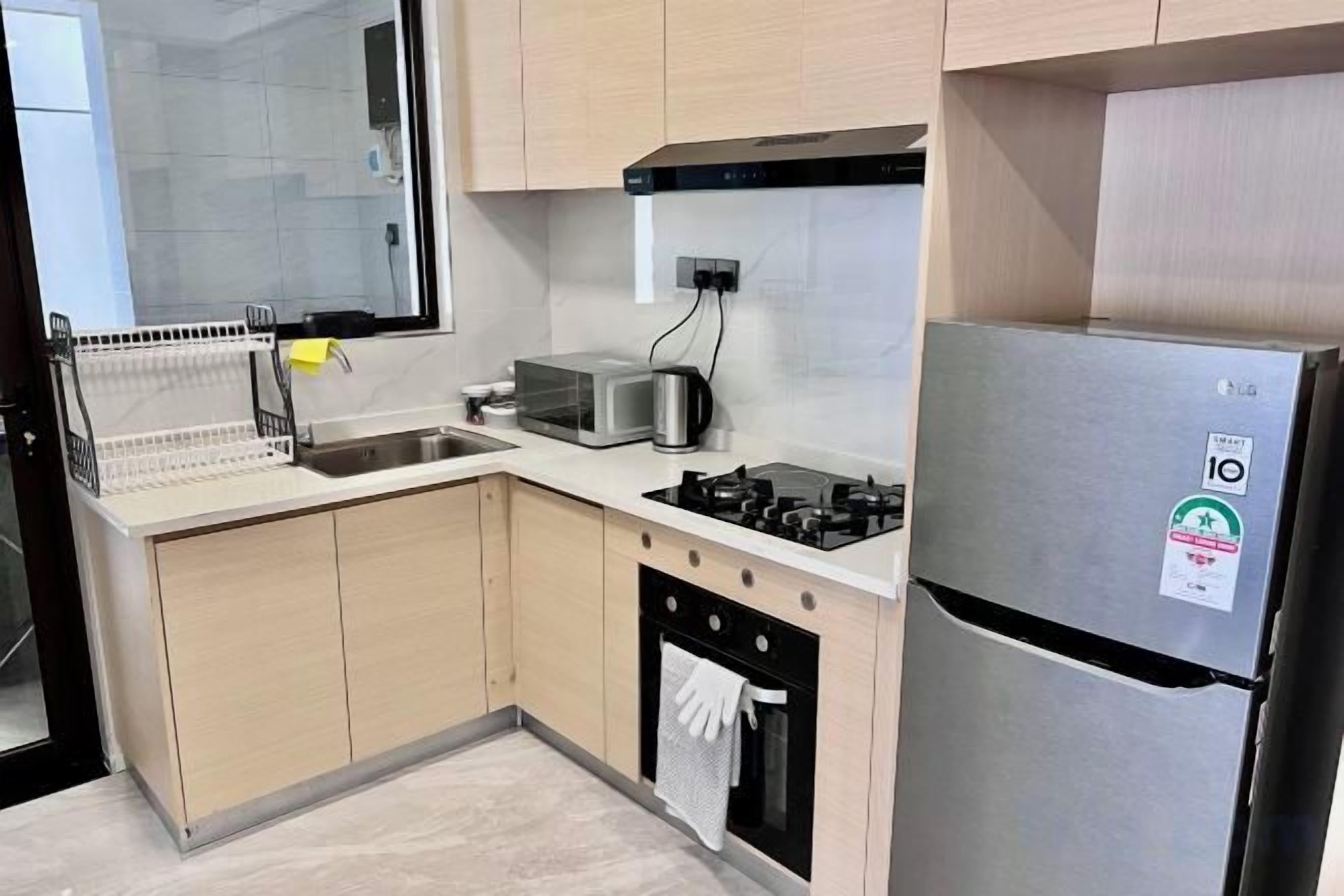 Una cucina con frigorifero in acciaio inox, tostapane e lavastoviglie.