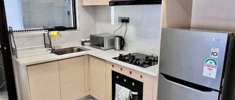 A kitchen with a stainless steel refrigerator, a toaster, and a dishwasher.