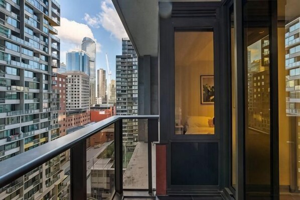 A high-rise building with a balcony overlooking a cityscape.