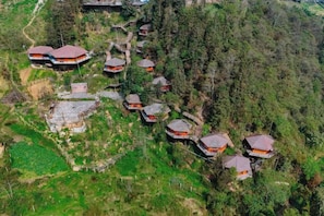 Un conjunto de edificios de estilo tradicional con techos inclinados, rodeado de un denso bosque.