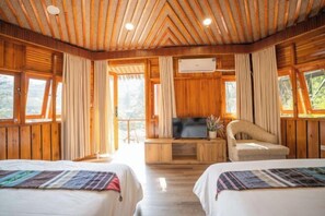 Una cabaña de madera con dos camas, un televisor y un sofá.
