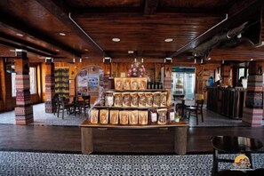 A wooden interior with a central display of packaged goods, a bar area, and a patterned floor.