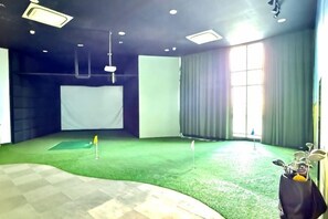 A room with a green carpeted area, a white screen, and a large window with curtains. - Macrolink 2B2R 7 pax Condo Medini near legoland (Iskandar Puteri)