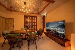 A dining area with a large table, chairs, a television, and a cityscape view. - [Mountain and Sea: Luxury bath villa/4 bedrooms/up to 11 people/Parking for 2 cars (Beppu)