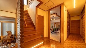 A wooden staircase leading to a room with a view of a dining area. - [Mountain and Sea: Luxury bath villa/4 bedrooms/up to 11 people/Parking for 2 cars (Beppu)