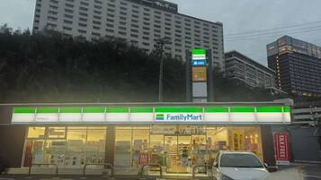 Una tienda FamilyMart con estacionamiento y un edificio al fondo.