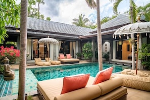 A poolside area with lounge chairs and a covered seating area, surrounded by palm trees and tropical plants. - Balinese 2 Bedroom Private Pool Villa (Kbr11) (Koh Samui)