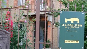 Indicador de "LES COULISSES du Chateau" amb un número de contacte.