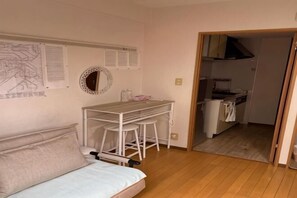 Una stanza piccola con un letto, una scrivania e angolo cottura.