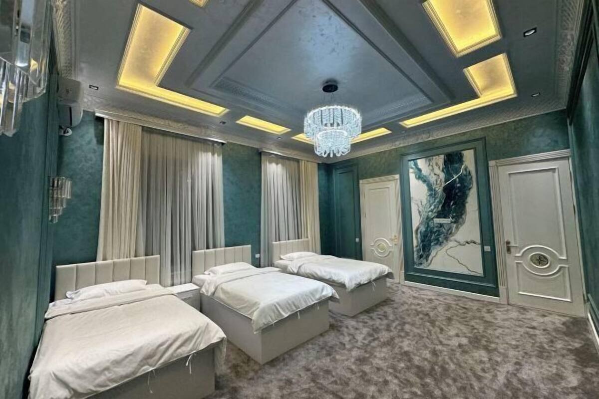 Ein Schlafzimmer mit zwei Betten, einer Kandelaber und einem großen abstrakten Gemälde an der Wand.