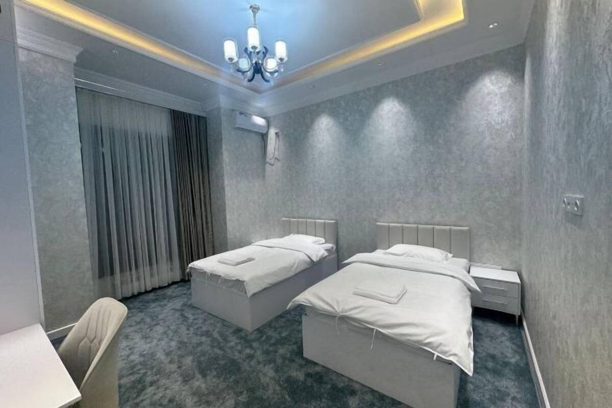 Ein Hotelzimmer mit zwei Betten, einem Schreibtisch und einem Stuhl.