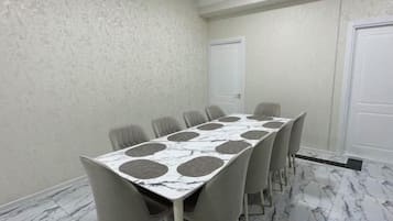 Una sala conferenze con un tavolo dal motivo marmorizzato e sedie grigie.
