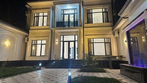 A multi-story building with a symmetrical facade, large windows, and a central entrance. - yuelai hotel (Tashkent)