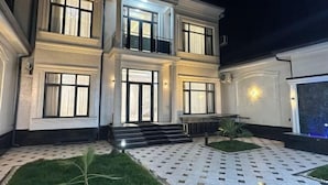 A two-story building with a symmetrical facade, large windows, and a central entrance with steps. - yuelai hotel (Tashkent)