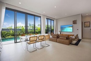 Una sala de estar moderna con un ventanal grande, un comedor y un sofá.