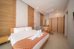 A modern hotel room with a large bed, a seating area, a mirror, and a wardrobe. - 3 Bedroom Seaview Pool Villa near Chalong Pier Phuket Warm Plus (Phuket)
