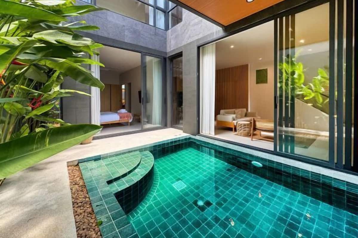 Una casa moderna con piscina, un soggiorno con divano e un'area pranzo.
