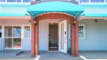 A building entrance with a brick archway and a blue awning.