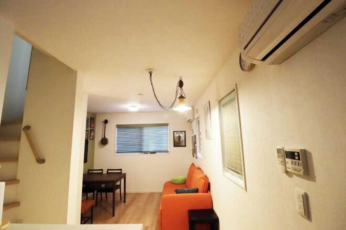 Un espace de vie compact comprenant un coin repas, un canapé et un escalier.