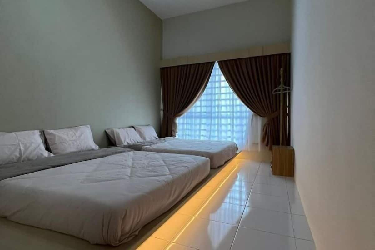 A hotel room with two beds, a large window with curtains, and a floor lamp.