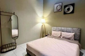 A bedroom with a bed, a bedside lamp, a wall-mounted mirror, and two framed pictures. - PoloStay Landed House 4 Room for 10 pax (Ipoh)