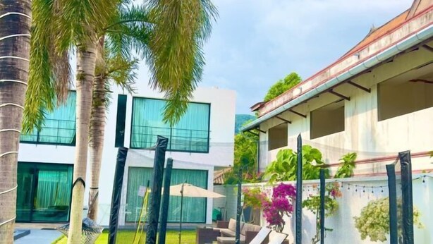 Un espace extérieur moderne comprenant un trampoline, des sièges et un patio couvert.