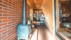 A narrow corridor with a brick wall, a wood-burning stove, and a wooden floor. - Pukōji Temple (Numata)