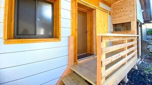A wooden cabin with a porch, a door, and a window. - Pukōji Temple (Numata)
