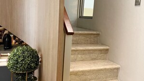 A staircase with beige steps and a wooden handrail. - Premium Luxury Home At Golf Island PIK (North Jakarta)