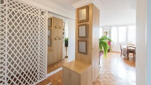 A room with a wooden cabinet, a white lattice partition, and a door leading to another room.