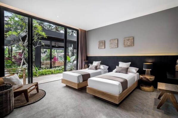 A modern hotel room with two beds, a large window, and a view of greenery. - Villa Jungle Paradise by BaliSuperHost (Bali)