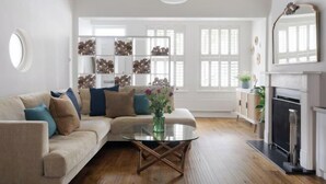 A living room with a sofa, coffee table, fireplace, and a bookshelf. - Luxury Family Home in Central Windsor with Large Garden, Games Room & Parking (Windsor)