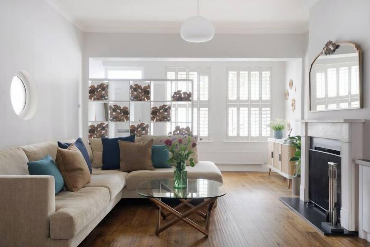 A living room with a sofa, coffee table, fireplace, and a bookshelf.