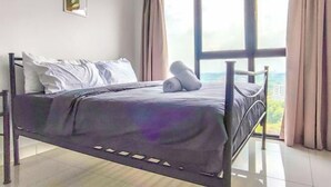 Een slaapkamer met een bed, uitzicht op de stad en een raam met gordijnen.
