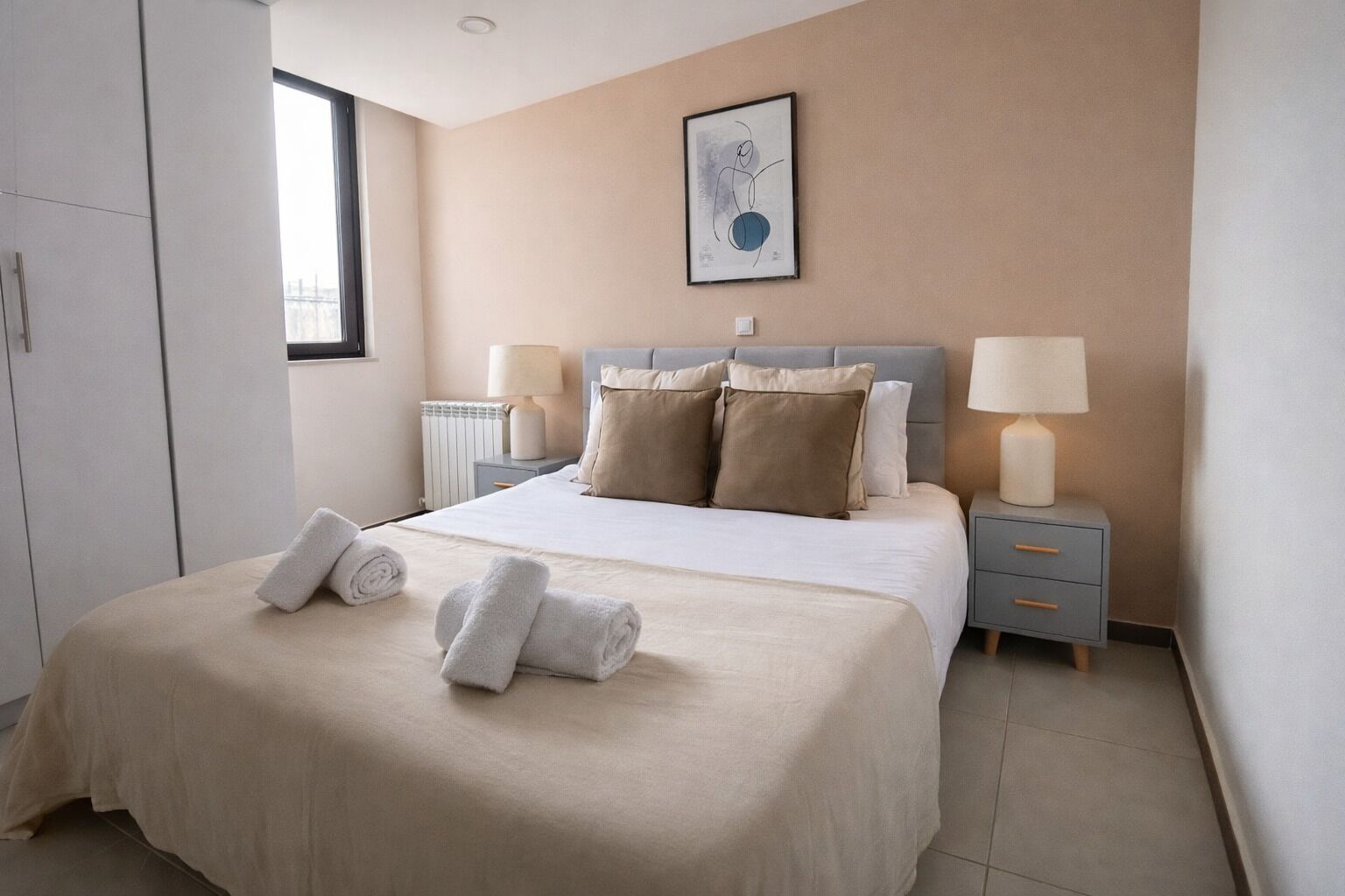 Habitación de hotel con cama, dos mesitas de noche, una ventana y un radiador.
