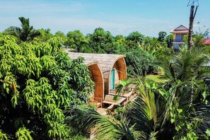 A treehouse with a wooden deck and archway entrance, surrounded by lush greenery. - NanaSky Kampot Residence (Kampot)