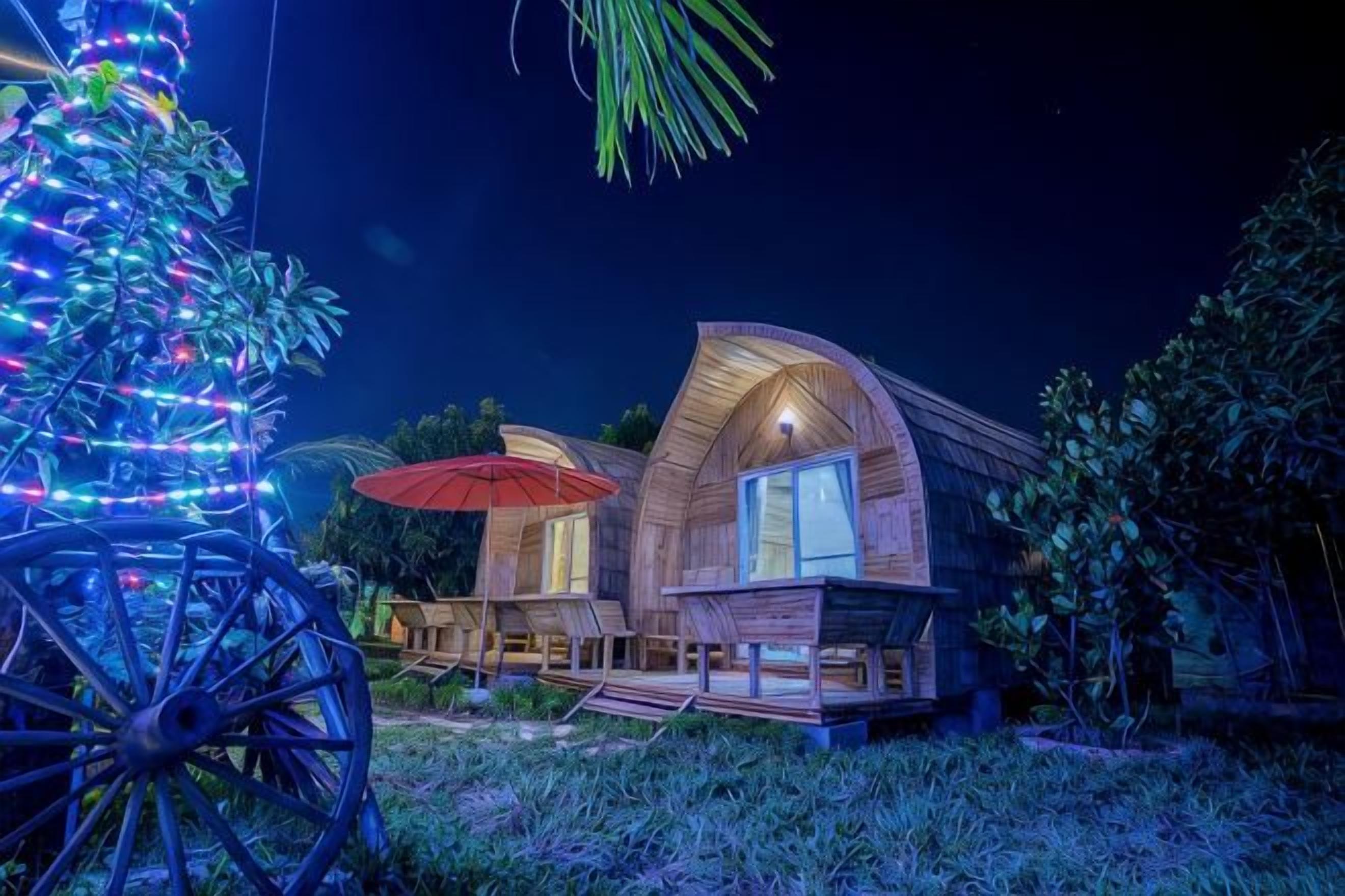 Une maison en bois avec un porche et un parasol rouge.