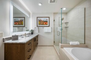 A modern bathroom with a glass-enclosed shower, a large mirror, and two framed pictures on the wall. - Snowcation Station | Exclusive Tamarack Perks (Tamarack)