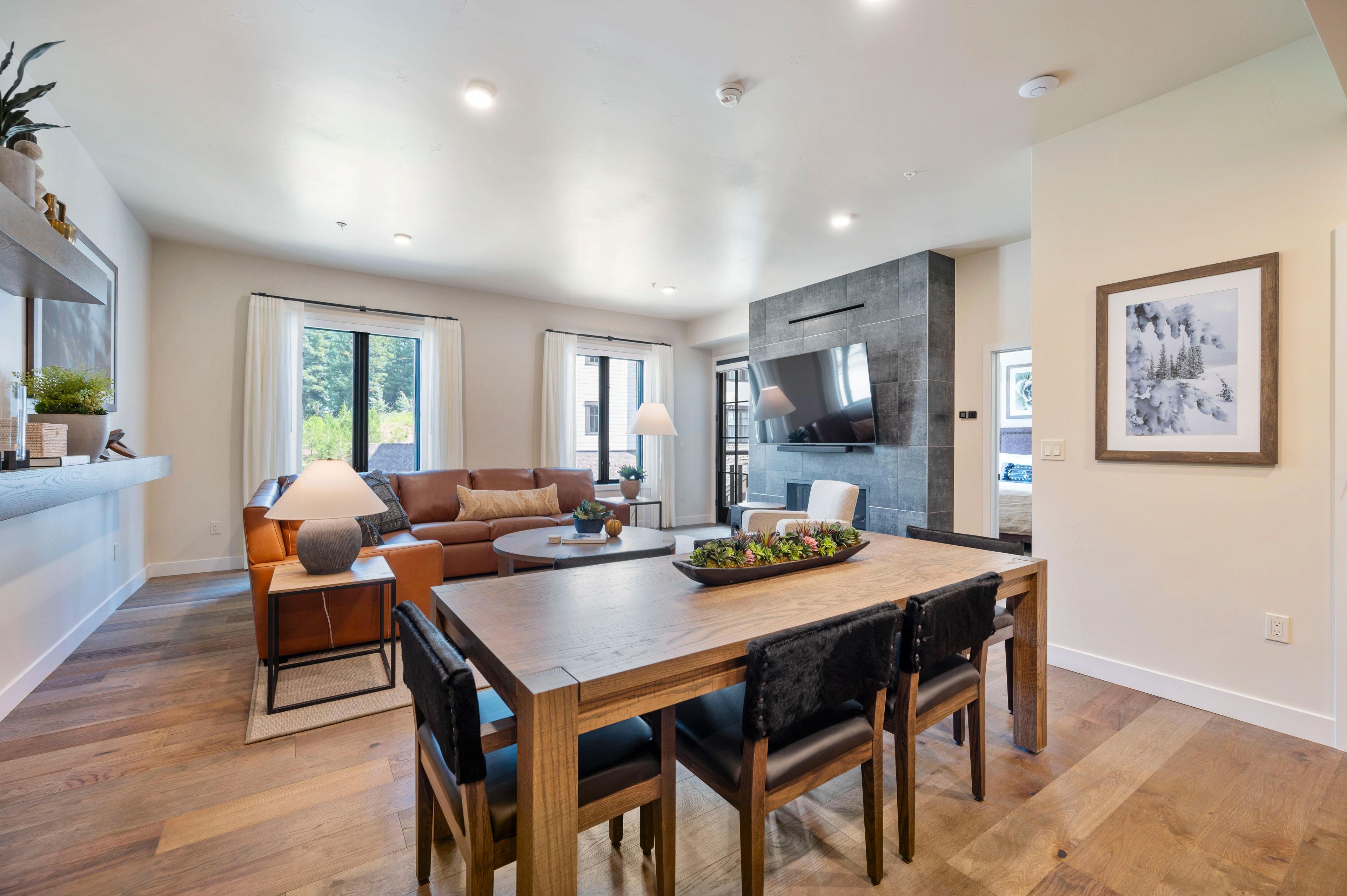A modern living room with a sofa, coffee table, and dining table.