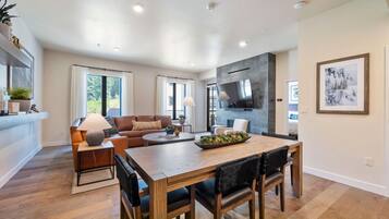 A modern living room with a sofa, coffee table, and dining table.