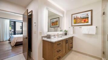 Un baño moderno con un espejo grande, armarios de madera y una zona de ducha.