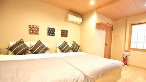 A hotel room with a large bed, a wall-mounted air conditioner, and a fire extinguisher. - Tamatsukan/Namba 6mins/Universal Studio 37 mins/Tsuruhashi 7mins/Nara30min (Osaka)