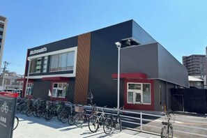 A McDonald's restaurant with a modern design, featuring a prominent logo, a bike parking area, and a clear sky. - Tamatsukan/Namba 6mins/Universal Studio 37 mins/Tsuruhashi 7mins/Nara30min (Osaka)