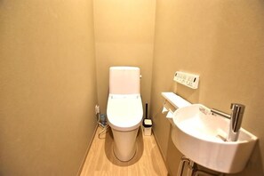 A small bathroom with a toilet, sink, and a wall-mounted electrical outlet. - Tamatsukan/Namba 6mins/Universal Studio 37 mins/Tsuruhashi 7mins/Nara30min (Osaka)