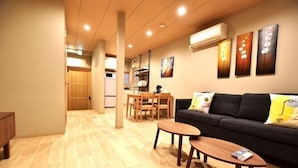 A modern living room with a sofa, coffee table, and dining area. - Tamatsukan/Namba 6mins/Universal Studio 37 mins/Tsuruhashi 7mins/Nara30min (Osaka)