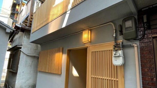 A building with a grey facade, a wooden door, and a small window. - Tamatsukan/Namba 6mins/Universal Studio 37 mins/Tsuruhashi 7mins/Nara30min (Osaka)