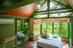 A room with a bed, a window, and a wooden ceiling. - Naralin Khaoyai (Pak Chong)