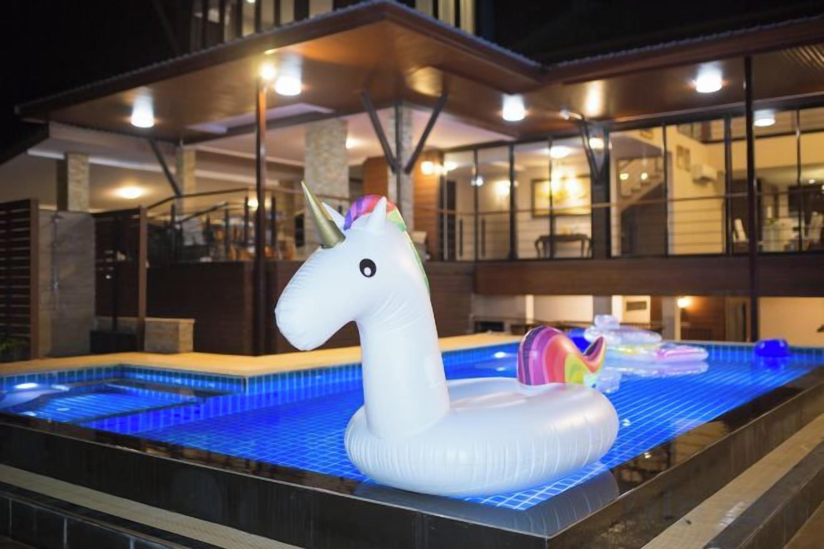 Una piscina con un flotador inflable de unicornio blanco.