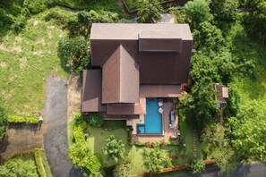 A large house with a swimming pool, surrounded by lush greenery. - Naralin Khaoyai (Pak Chong)