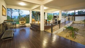 A spacious interior with a wooden floor, a staircase, and a view of the outdoors. - Naralin Khaoyai (Pak Chong)